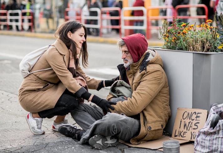 Young woman giving money to homeless beggar man sitting in city. stock photo Homelessness, Assistance, Support, A Helping Hand, People